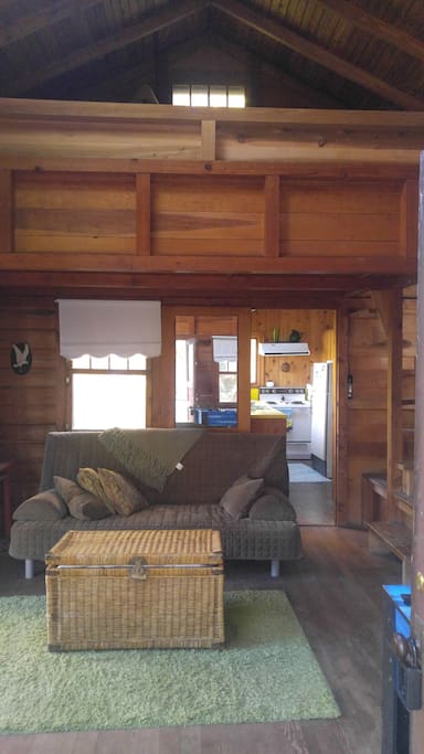 Open family room with loft above. Full sofa sleeps two.