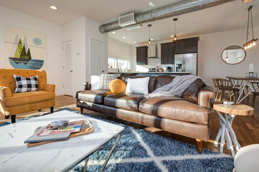 Natural light pours into the spacious living room that features 2 chic armchairs and a cozy couch.