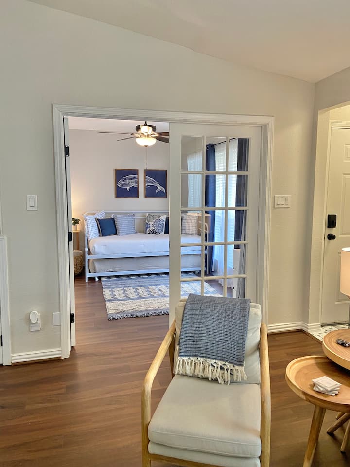 חדר השינה הקדמי ממש ליד הסלון. וילונות פרטיות תלויים ממש מאחורי דלתות הזכוכית.