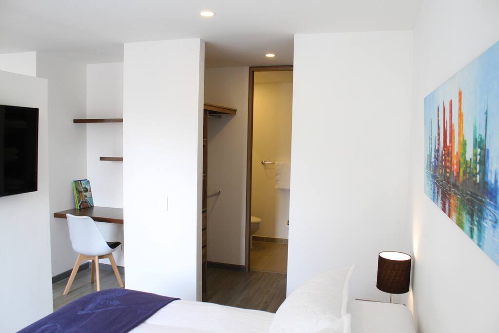 View from bedroom into closet, main bathroom and the working space.
