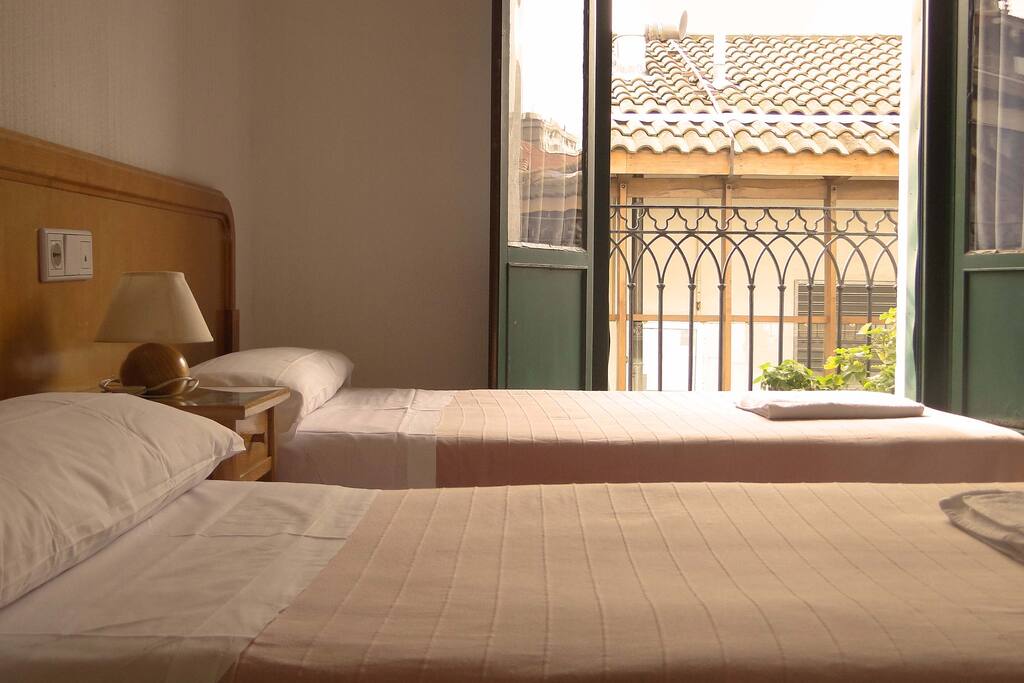 Habitación doble con dos camas y balcón exterior con vistas a las calles del Casco Viejo