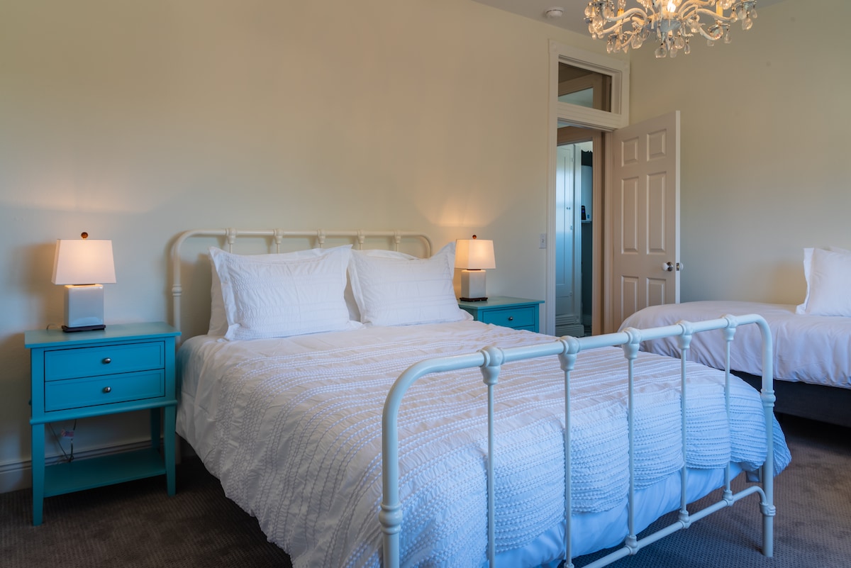 Cuarto dormitorio de arriba con una cama tamaño queen y una cama de matrimonio adicional. 