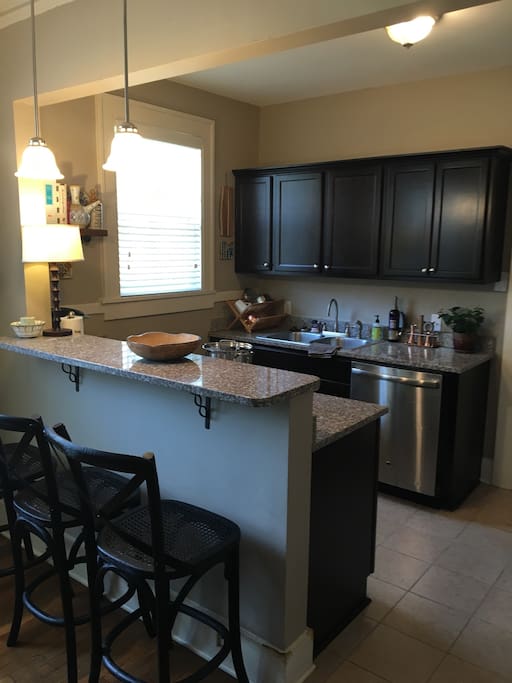 Updated kitchen with granite, stainless steel, gas cooktop and all needed utensils. Eat in bar.