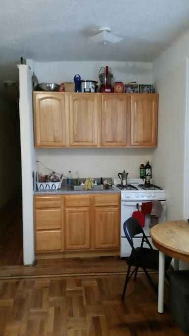 Full kitchen, microwave, french press, full fridge is to the left of the hallway.