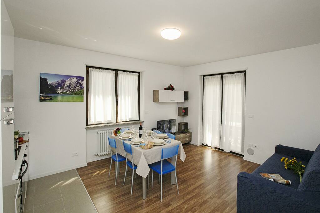The bright living room with sleeping sofa, dining set and exit to the terrace
