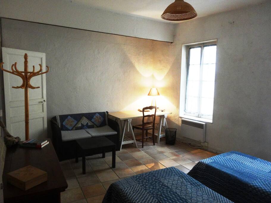 La chambre fait 20m2 et dispose d'un petit canapé et d'un bureau