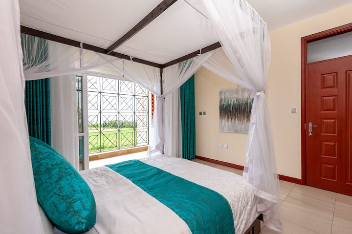 חדר שינה ראשי בקומה התחתונה עם מרפסת המשקיפה לאגם