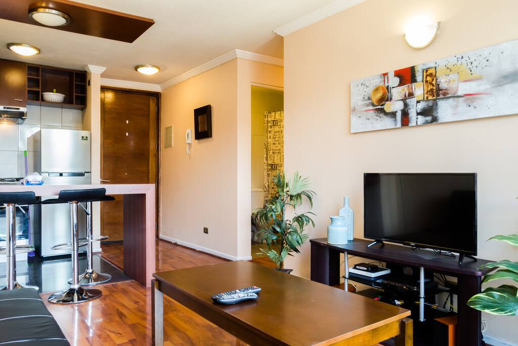 Living con televisor pantalla plana y una radio