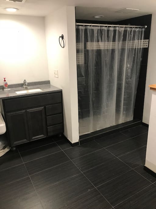 Private bathroom with large tile shower.
