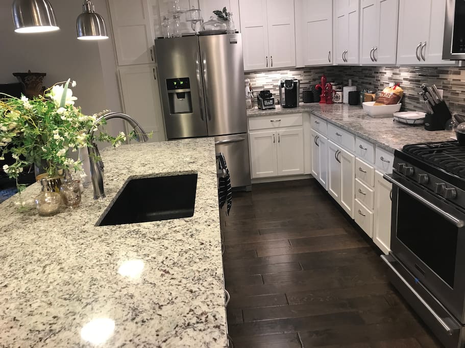 Spacious kitchen with welcoming wood, elegant granite and professional series appliances.