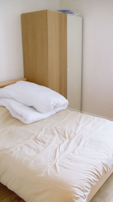 Our light and spacious double bedroom with desk, wardrobe, under bed drawers, and a bedside table and lamp
