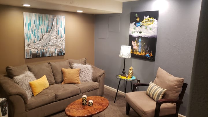 Comfy living room with pullout couch, TV, plenty of art.