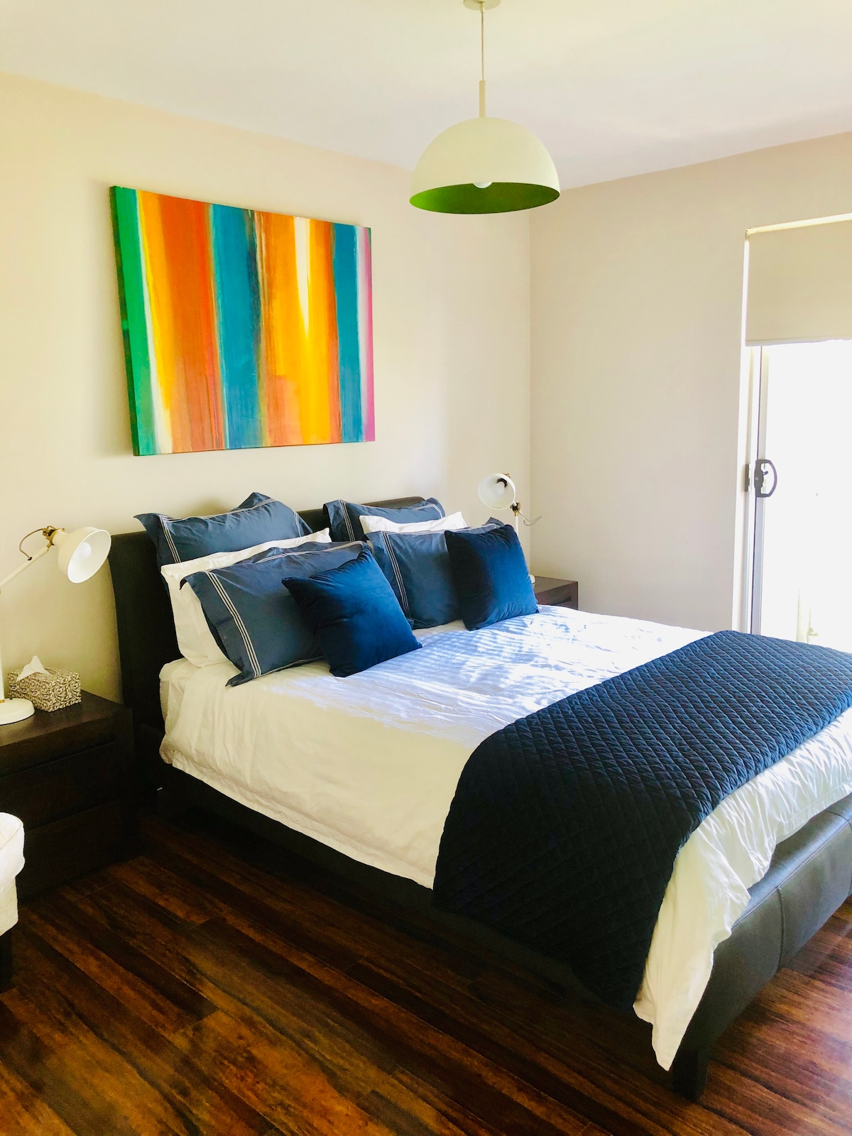 带阳台和酒店式Sheridan床上用品的卧室。嵌入式悬挂衣服 