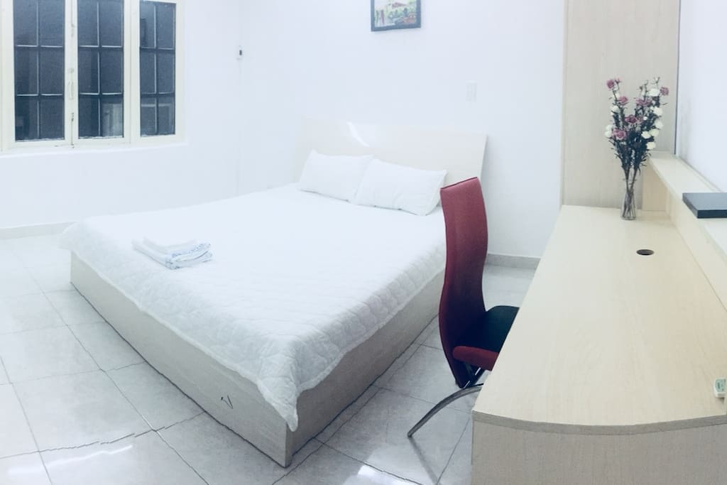 A large window is next to the bed