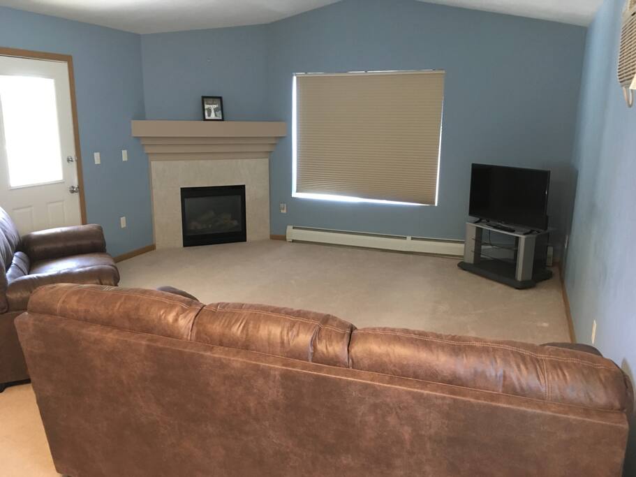 Living room with couch love seat and fireplace.