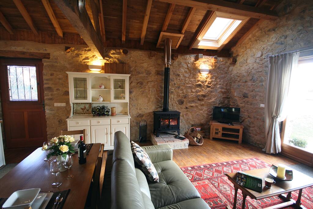 Spacious vaulted open plan living area with cosy log burning stove