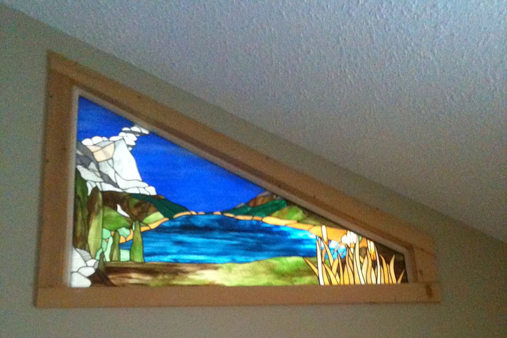 Stained glass window in Master bedroom lit from behind by a sky light