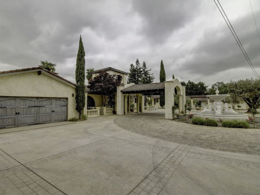 Marble fountain surrounded in natural stone circular driveway.