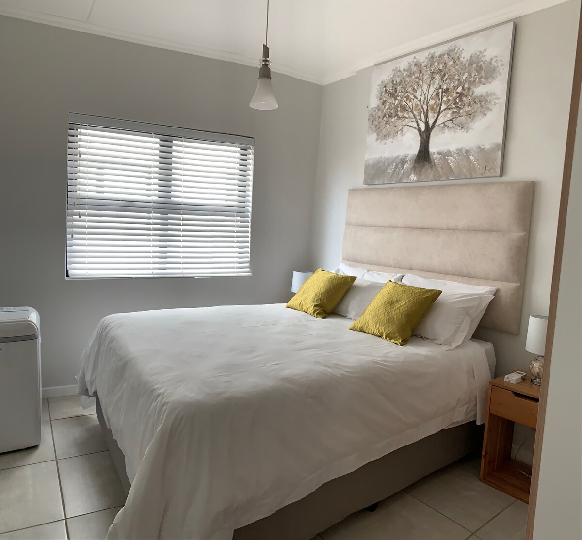 Spálňa s pohodlnou posteľou Queen XL s dvoma masívnymi drevenými podstavcami, 2 bočnými lampami a šatníkom.