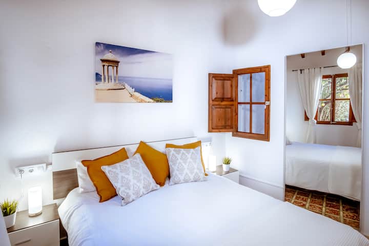 Dvojlôžková izba s výhľadom do záhrady a manželskou posteľou.