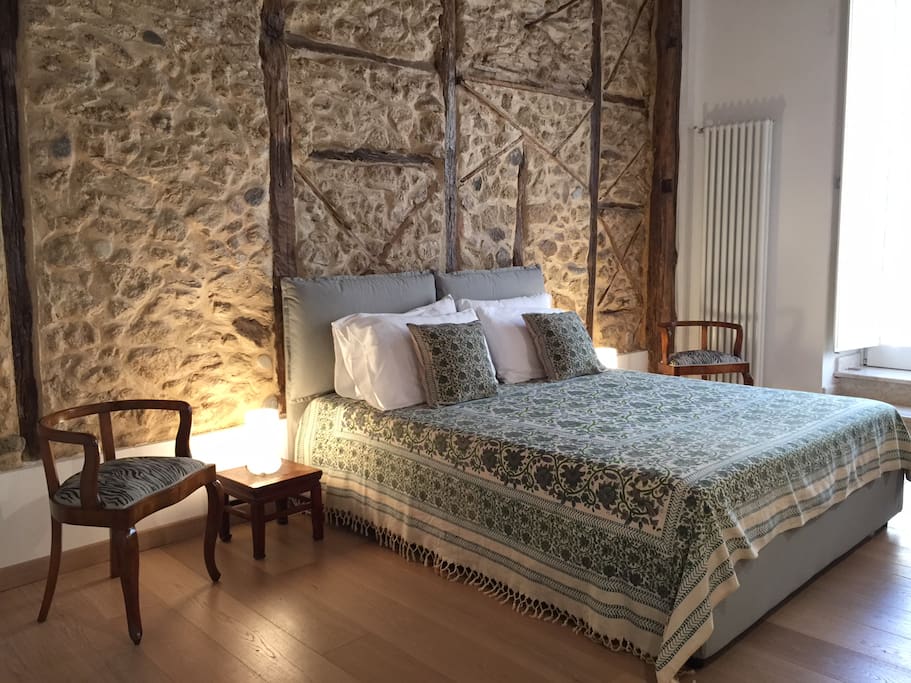 master bedroom with restored stone wall