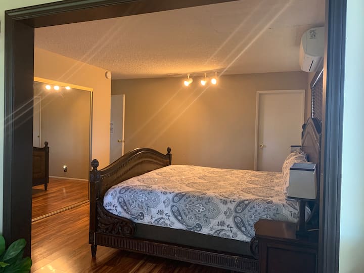 Suita kryesore e dhomës së gjumit me krevat dopio "king", me pamje nga dera që të çon në banjën e plotë