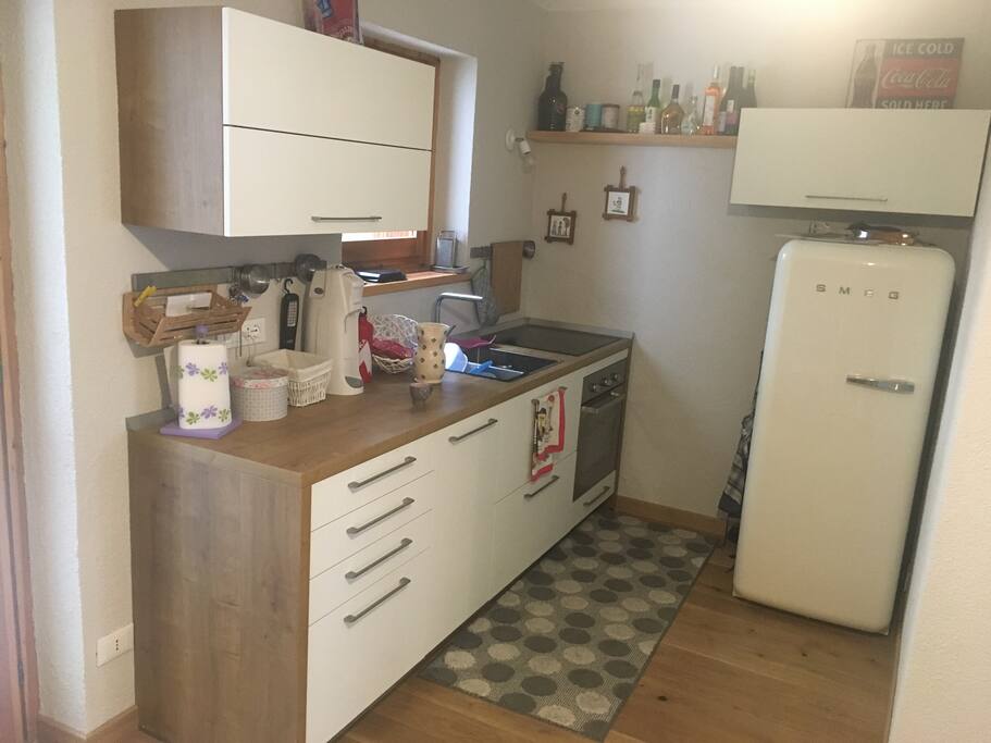 Cucina moderna completa di piano cottura a induzione, forno, frigo e lavastoviglie, macchina caffè Nespresso
