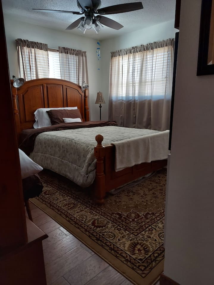 سرير بحجم كوين، منضدة سرير، خزانة ملابس، خزانة ملابس، تلفزيون ذكي كبير، مروحة سقف.