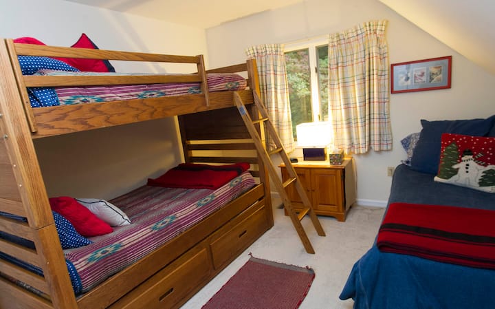 Soba na drugom katu uz rijeku s krevetima na kat i pomoćnim krevetom. 