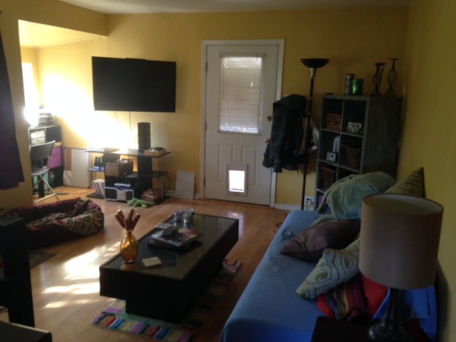 Living room with T.V., Entertainment Center, & Table.