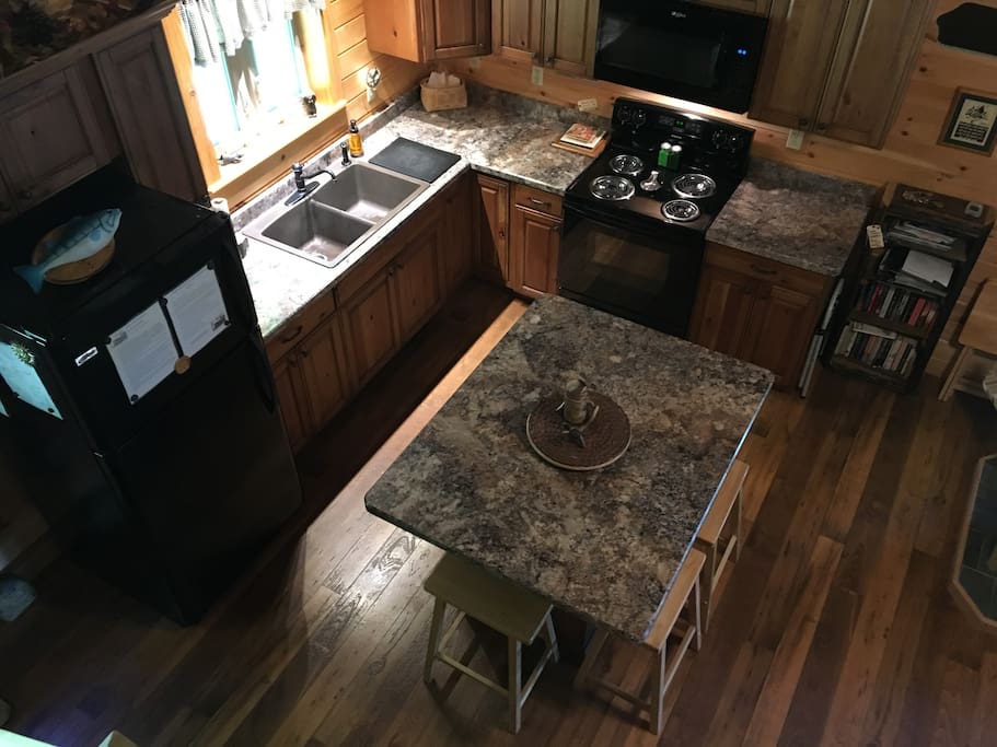 Taken from loft stairs. Six stools surround the island. Knotty cherry cabinets, complete with Cuisinart coffee maker (coffee & filters included), toaster, all major appliances, fully stocked kitchen. Feel free to use our condiments, paper products, dish soap, etc. Night light provided.