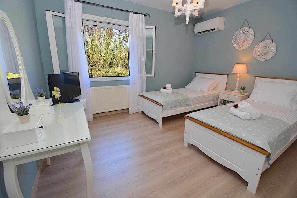 Bedroom 2 with two single beds. They can join in order to create a large king size bed. Garden view.