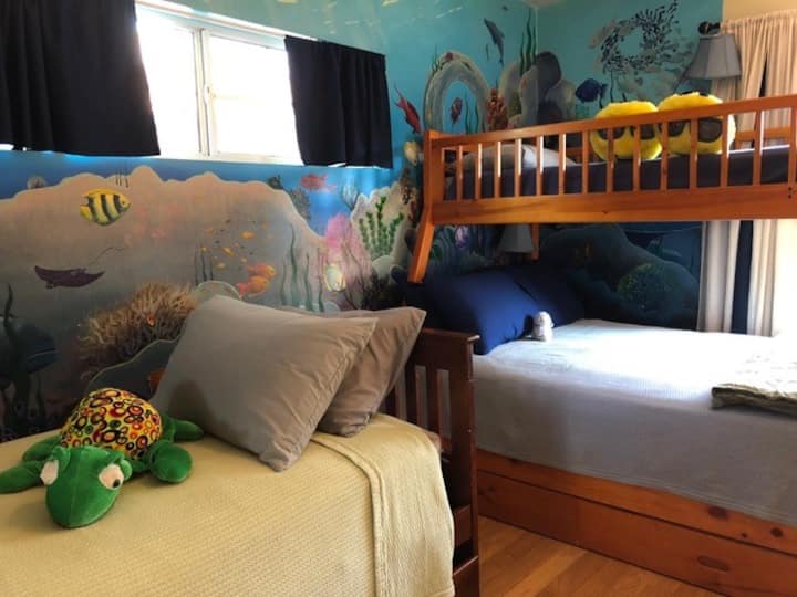 Hand-painted oceanic mural is the backdrop for the bunkroom. 
Top twin, bottom full. 
Left is a twin with a twin trundle underneath.
