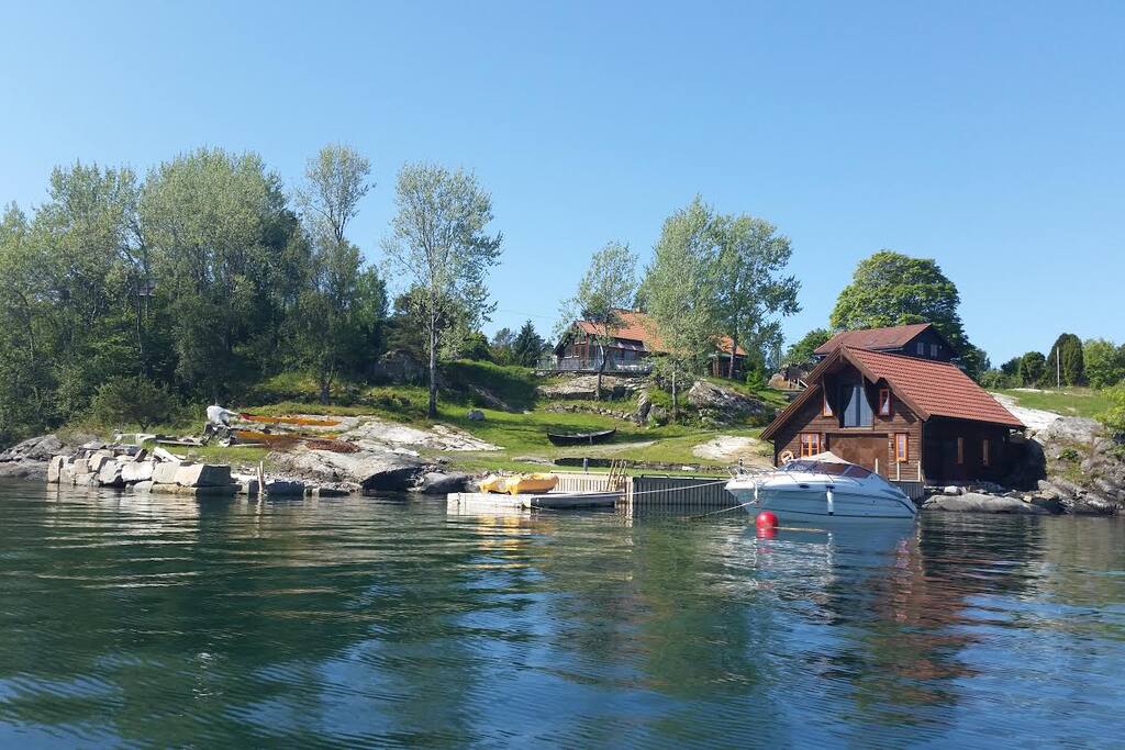 eiendommen sett fra sjøen. Leiligheten i huset bak naustet