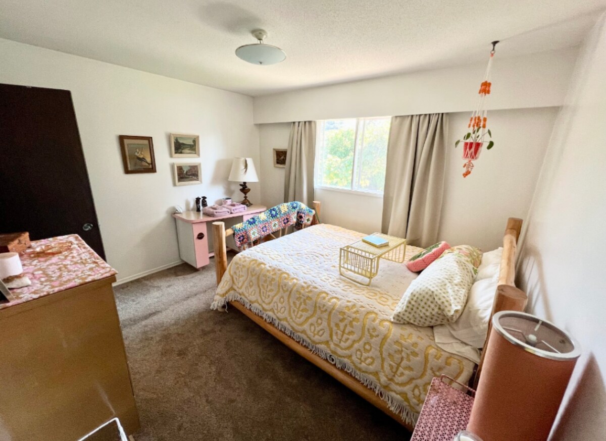 חדר שינה מואר ומזמין עם קסם וינטג', מצעים נעימים ושפע של אור טבעי - מעוצב ללילות מרגיעים ובוקרים עליזים.