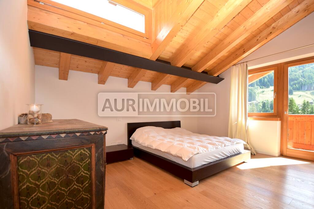 Camera da letto padronale con arredo caratteristico originale e vetrata luminosa che collega il terrazzo