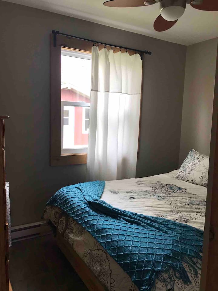 ห้องนอน 3 มีเตียงควีนไซส์พัดลมเพดานโต๊ะข้างโคมไฟกระจกตู้เสื้อผ้าและตะกร้าซักรีด  