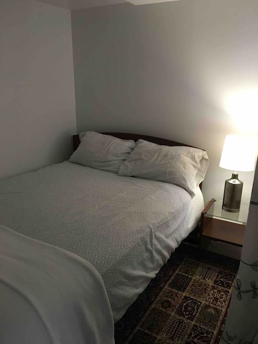 Small bedroom with double bed. Bedroom has lower ceiling.