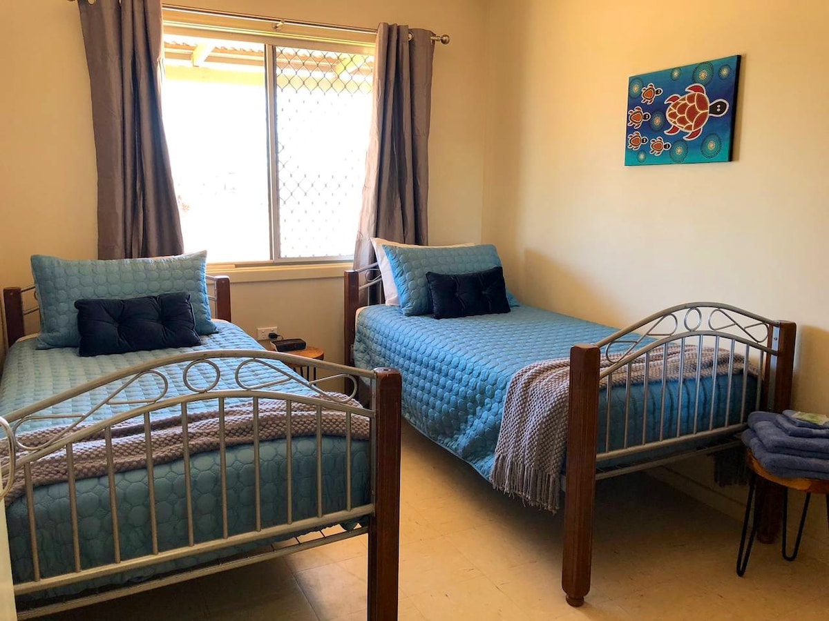 Second bedroom with two comfortable single beds and quality linen.