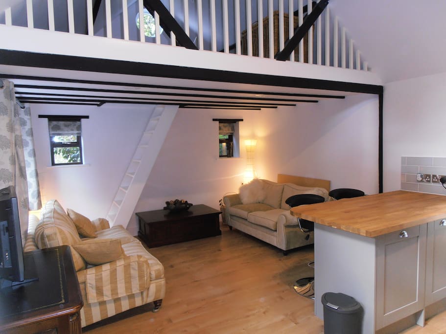 The living area (with mezzanine level above) with a sofa bed and pull out dining table and chairs