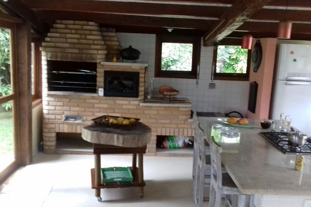 churrasqueria com ambiente de lazer completo, com sala de tv cozinha americana com fogão normal e alenha 1 geladeira e um freezer para bebidas