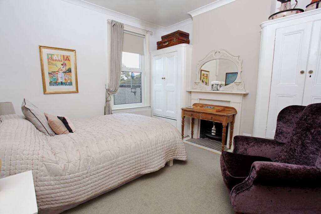 Victorian room with original wardrobes and ornamental fireplace.