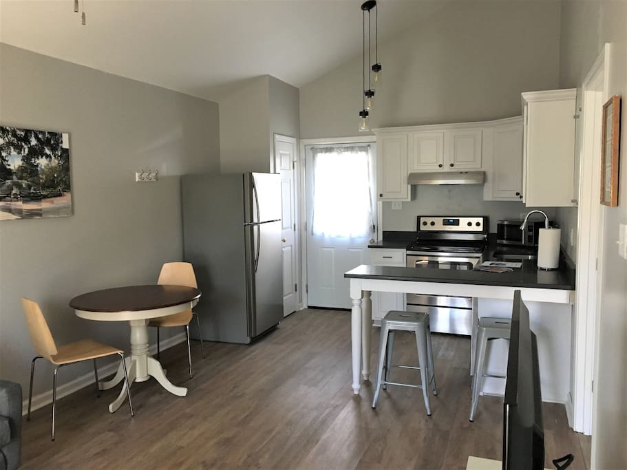 Open kitchen with dining table. Full sized oven, fridge, and dishwasher.