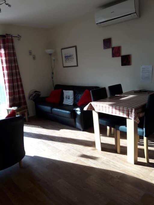 sitting room with fold down sofa bed, patio doors, dining table and chairs