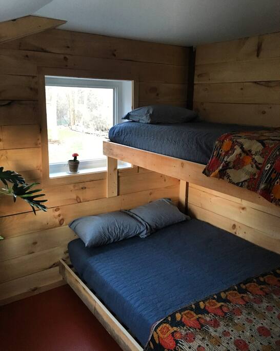This light filled corner room has one queen bed and one single bunk. It's named after a good friend who helped us build the studio.