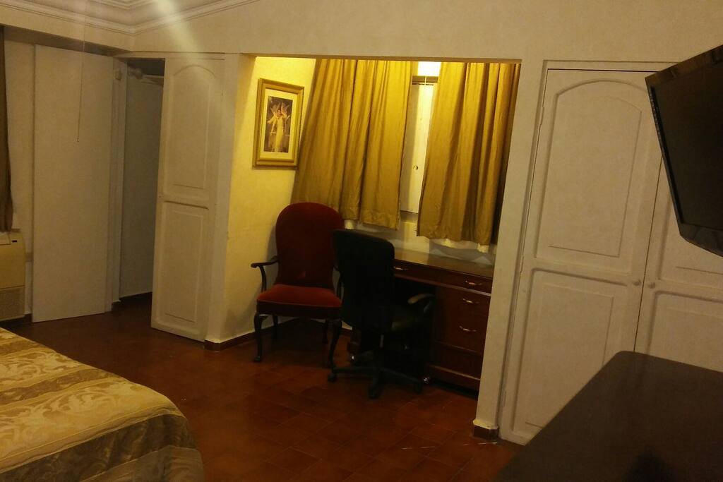 escritorio para trabajar con luz de techo individual, silla para lectura y dos closet o roperias con ganchos individuales