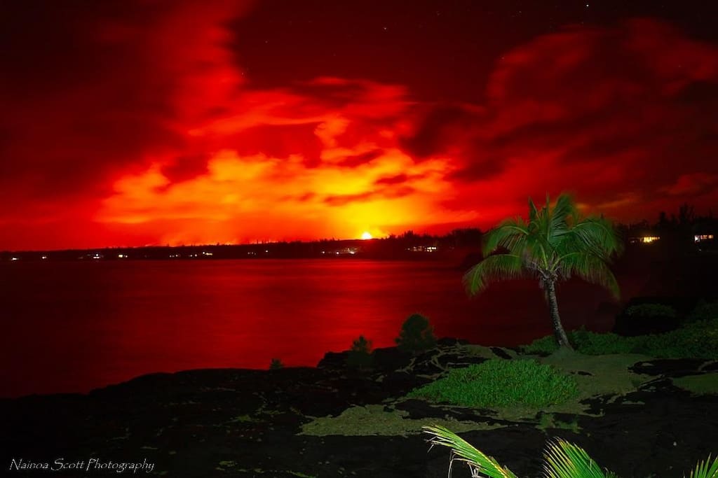 A view from the house at night looking at fissure 8 and the glow of the lava as it heads towards the ocean