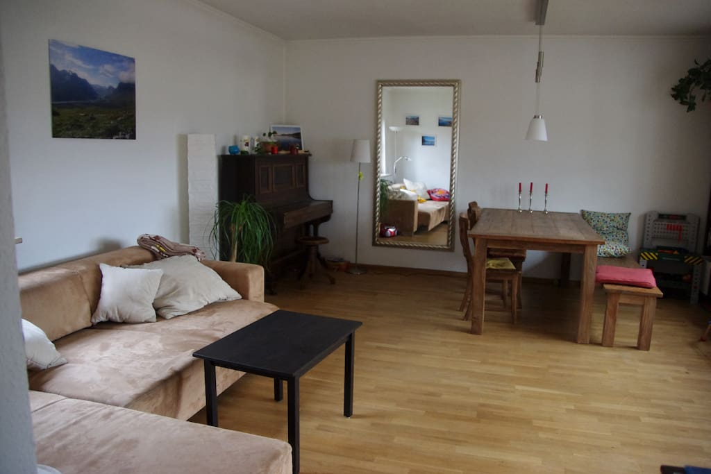 Wohnzimmer mit großem Tisch, Couch und Klavier