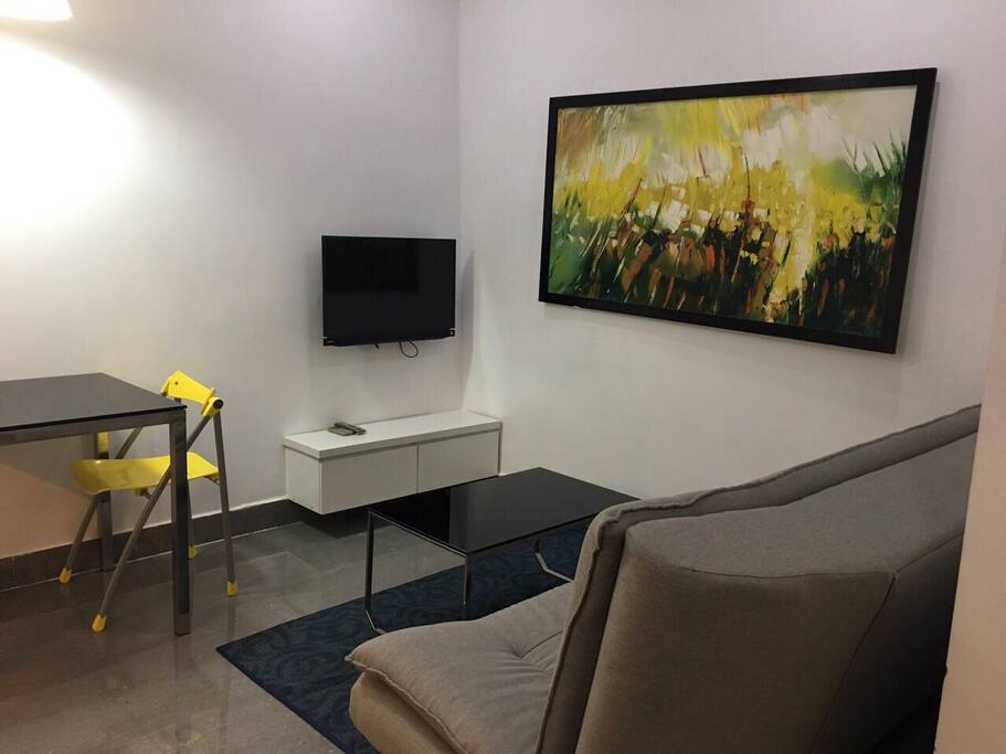 Living room with a TV, a sofa, 2 tables and 2 chairs