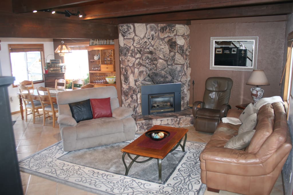 Open living room with plenty of seating, fireplace, & large flat screen tv.